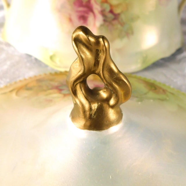 This is a pale green biscuit jar by Reinhold Schlegetlmilch with a pink floral design, slight metallic sheen and a...