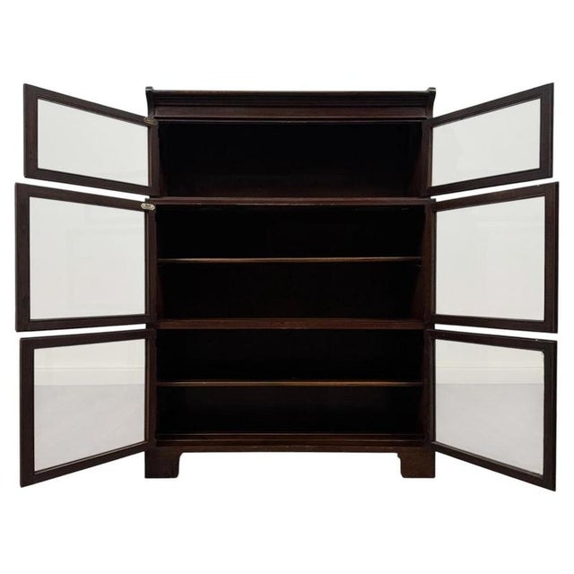 An elegant early 20th-century English display cabinet, finely crafted from oak and distinguished by its unusual three-tier...