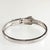 Hinged bangle crafted of sterling silver metal in a style imitating antique buckle bracelets. Finely crafted with bead set...