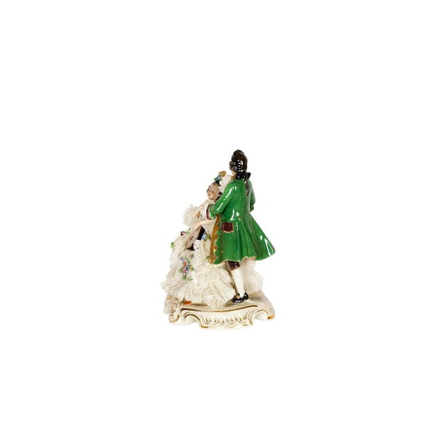 A Neapolitan Capodimonte porcelain in the Baroque style depicting a french salon scene, a woman seated in an armchair...