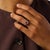 This striking vintage cluster ring centers on a richly colored oval cut ruby weighing approximately 0.50 carat, offering a...
