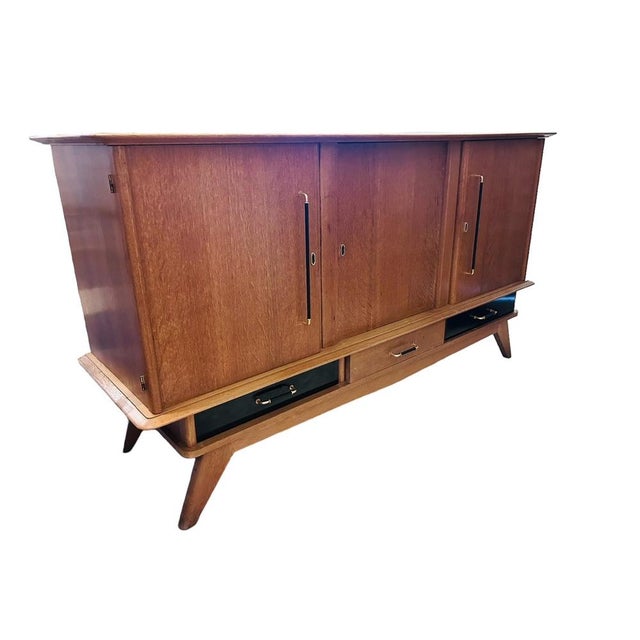 Oak buffet from the 1950s with three doors and three drawers Brass handles and keys facade of melamine drawers Typical...