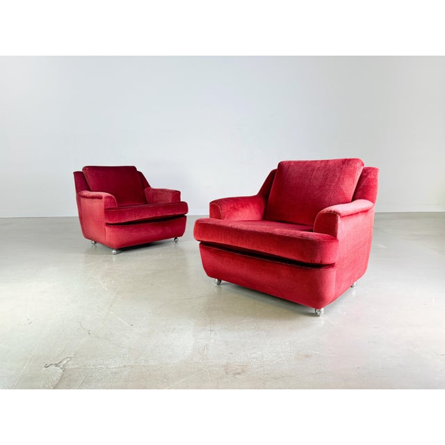 We are offering two beautiful vintage armchairs for sale, probably from the 1960s. The armchairs are covered with a red...