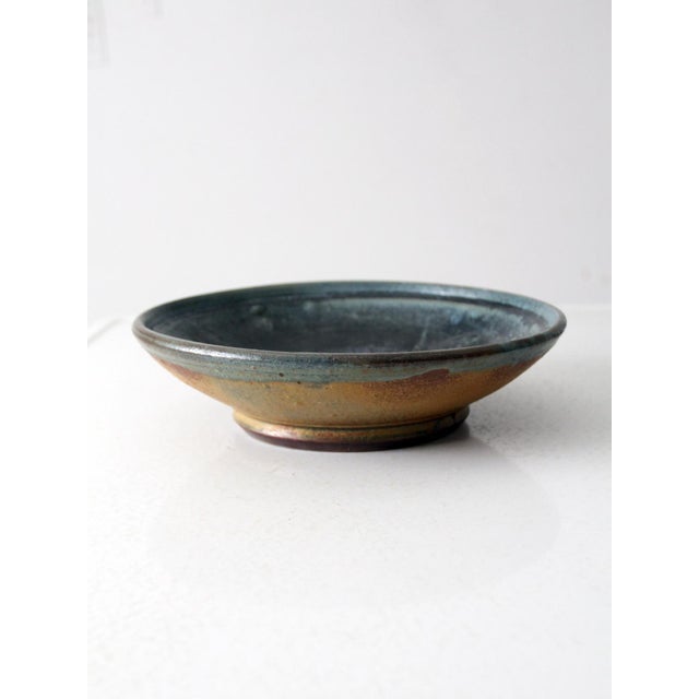 This handcrafted vintage bowl has a wide, shallow form and substantial weight, perfect as a serving piece or decorative...