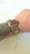 Gold-tone woven mesh slide bracelet featuring an ornate rectangular center setting with a deep purple