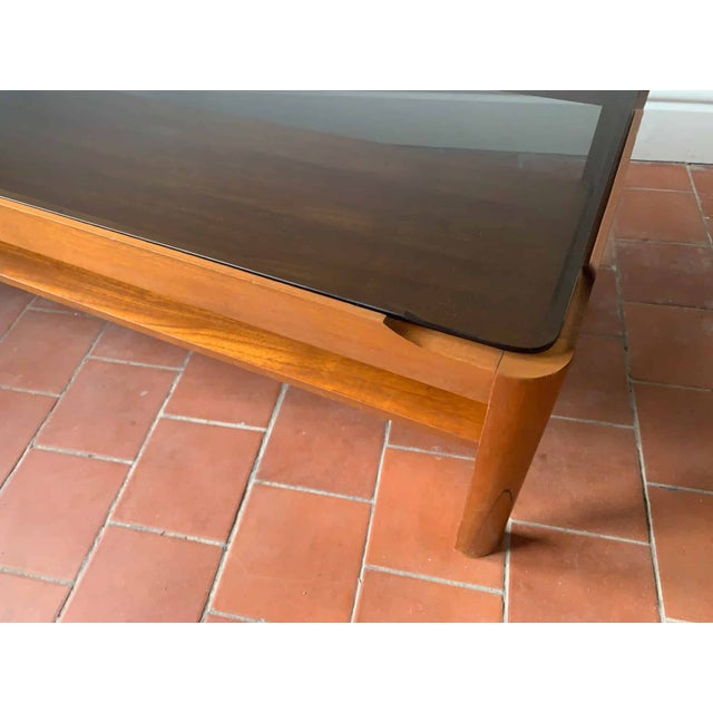 Mid century modern coffee table by respected English maker ‘Myer’. Solid countered teak frame with thick smoked glass...