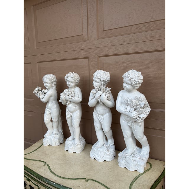 A stunning and rare set of four Neoclassical style Italian white porcelain Allegorical putti or cherubs representing the...