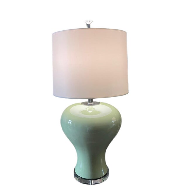 Refined handcrafted porcelain table lamps featuring a sculptural, hand-shaped body finished in a glossy fired green glaze....