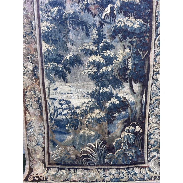 Beautiful 18th-century French verdure tapestry depicting a charming pastoral woodland scene. A bird is perched among the...