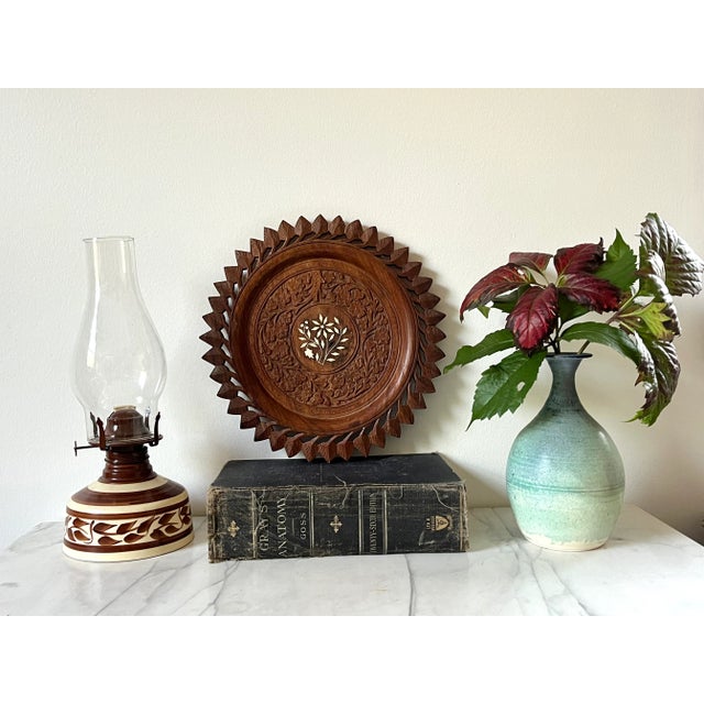 Vintage hand carved wooden plate, Made in India. The round plate features ornate decorative floral and scroll panels with...