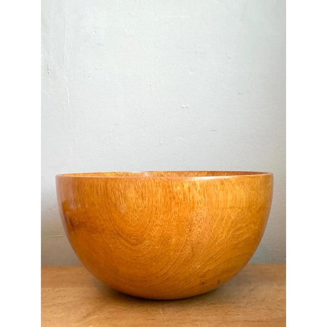 This vintage handcrafted wooden bowl is a study in pure, sculptural simplicity, its deep, hemispherical silhouette...