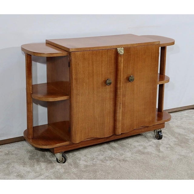 Bar cabinet on casters, made of walnut veneer with sycamore interior. This brightly colored piece has two doors featuring...