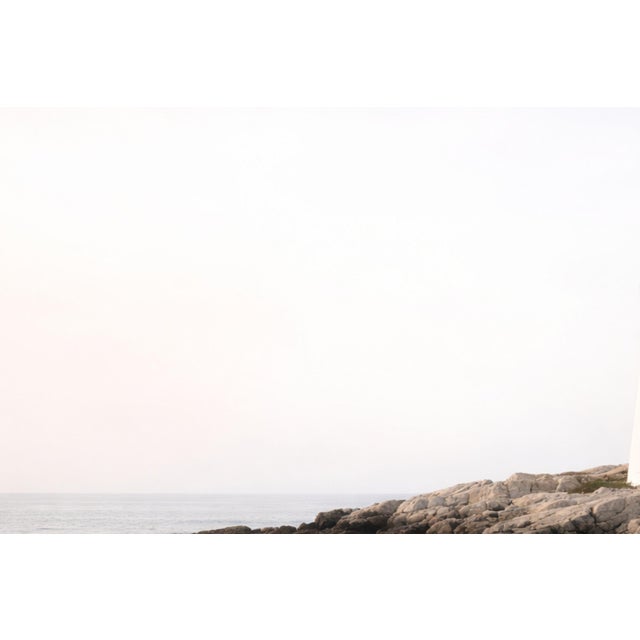 Coastal landscape artwork capturing a lighthouse overlooking a rugged shoreline with gentle ocean movement and soft,...