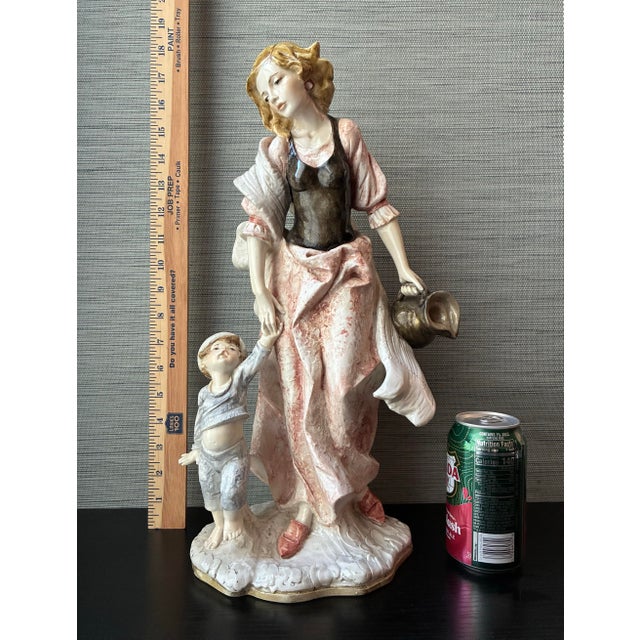 This beautiful vintage Italian sculpture by renowned artist Amilcare Santini features a tender depiction of a mother and...
