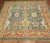 An mid 20th century hand-woven turkish oushak square rug with a a large palmette all over design on a green ground. This...