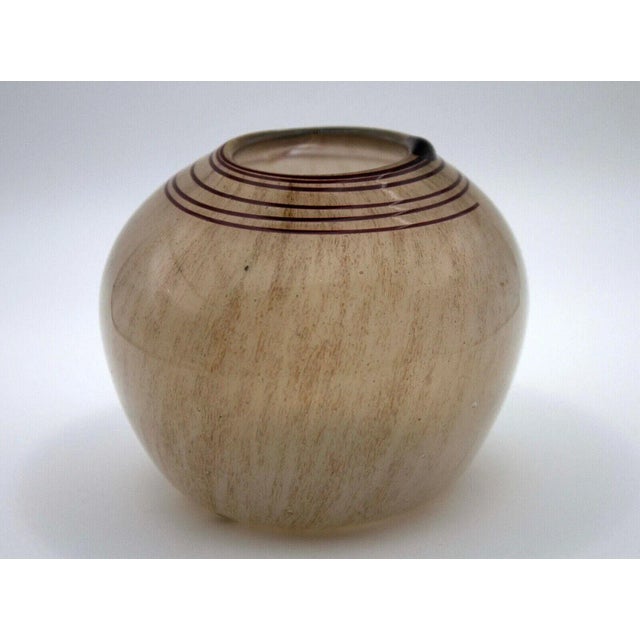 A contemporary earth toned glass vessel with a brown swirl design on the lid by Willem Hessen. Signed on bottom. From a...