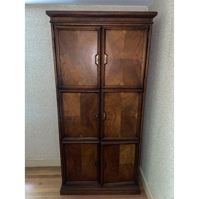 Beautifully crafted solid wood armoire by Drexel Heritage featuring classic paneled doors, generous interior storage, and...