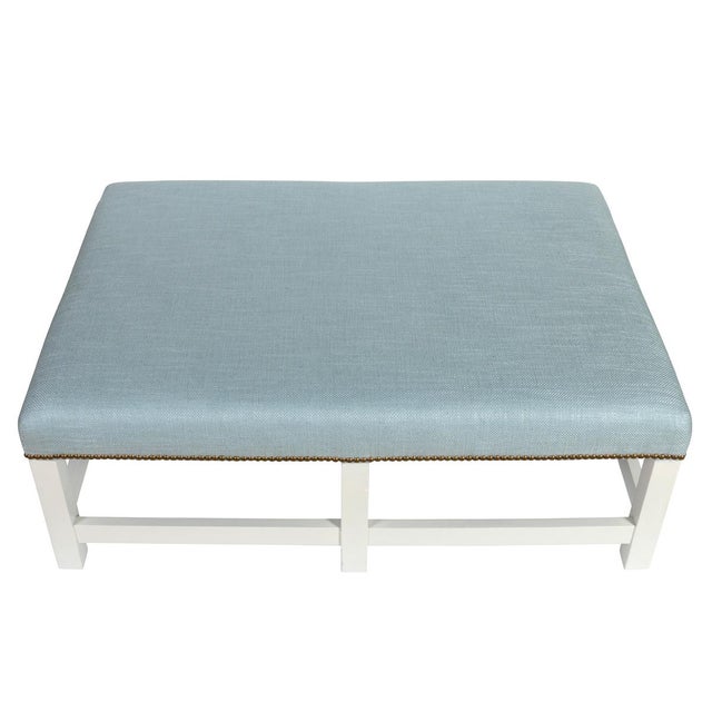 Large ottoman newly upholstered in Pierre Frey soft blue fabric with nailhead trim detail and painted white square legs...