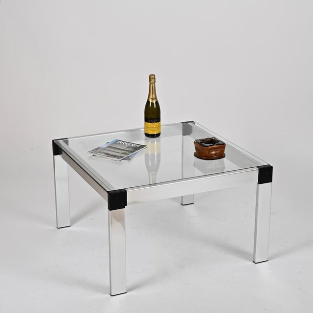Wonderful and iconic square coffee table in brushed aluminum and black lacquered details, completed by a crystal glass...
