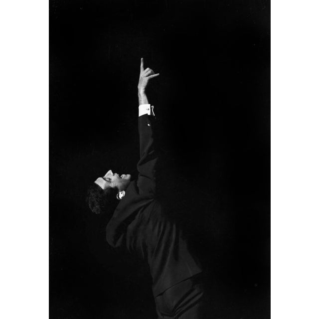 This photo shows the French singer Gilbert Bécaud during a concert in East Berlin in 1964. In the image, Bécaud is...