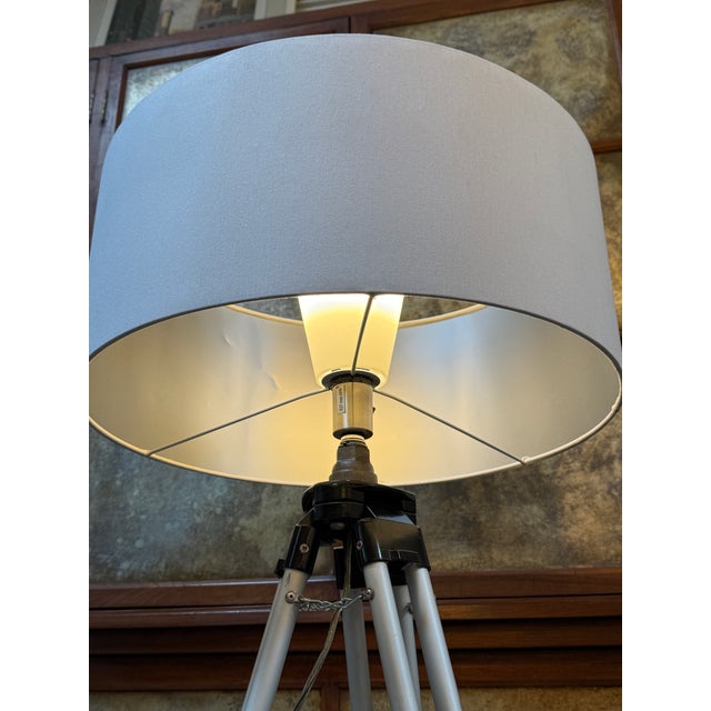 Design Plus Gallery presents a Surveyors Floor Lamp. The lamp has a tripod base that can easily close up at a moments...