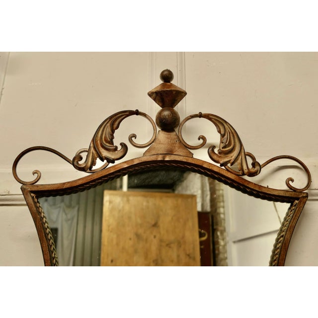 Metal Wall or Console Mirror with Shelf An elegant piece in the French provincial style, the mirror has an unusual shape...