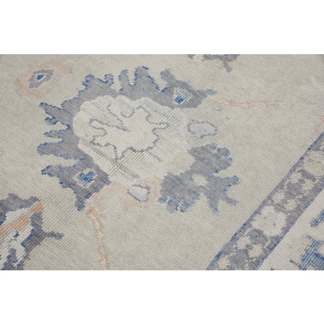 This modern Turkish Oushak rug is a stunning piece of art that has been handwoven using traditional techniques by skilled...