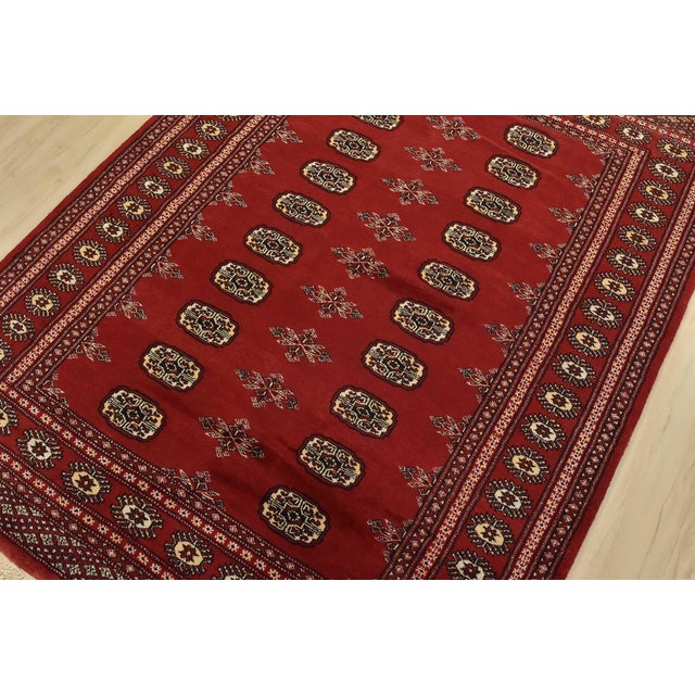 A tribal Bokhara rug hand-knotted with fine wool on a cotton foundation. This rug features rows of repeating medallions...