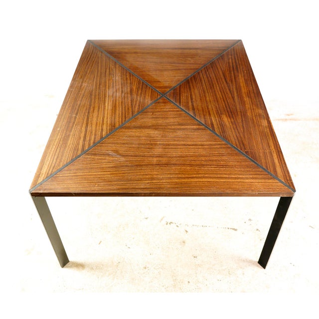 Modern style table with dark toned rosewood complemented by black steel legs and an X structure running through the...