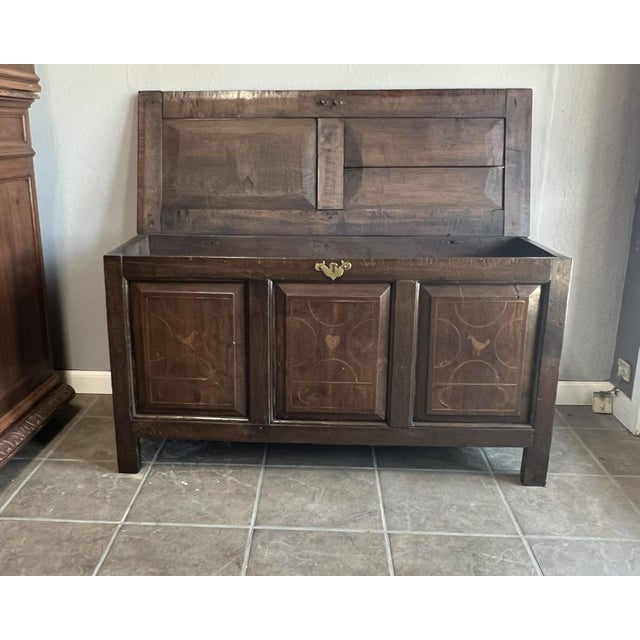 This antique French oak blanket trunk features hand-inlaid designs with charming heart and dove motifs, symbolizing love...