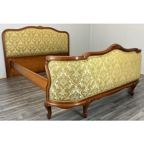 A striking Vintage French Louis style upholstered double bed frame, featuring elegant carved woodwork and decorative...