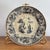 A French rebus puzzle plate, transfer printed in black on a white semi-porcelain body. When solved, the picture puzzle...