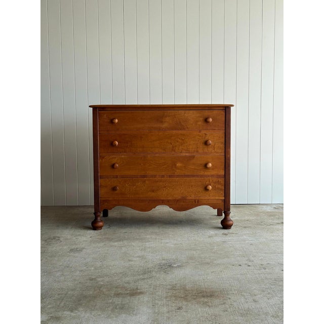Antique maple chest of drawers with a broad plank top and visible pegged construction. Four drawers with original wooden...