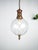 : Beautiful clear globe pendant light caged in brass wire. Constructed out of glass with brass fixture. Up to 250V...