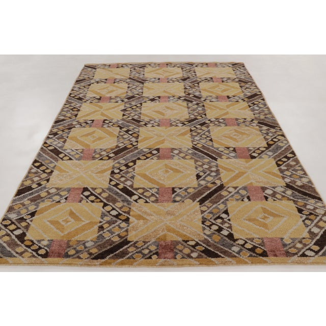 This 7x10 contemporary Scandinavian rug, hand-knotted in wool, features a bold geometric lattice with gold medallions,...