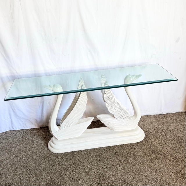 This striking Hollywood Regency console table features a sculptural pair of carved wooden swans gracefully lifting a...