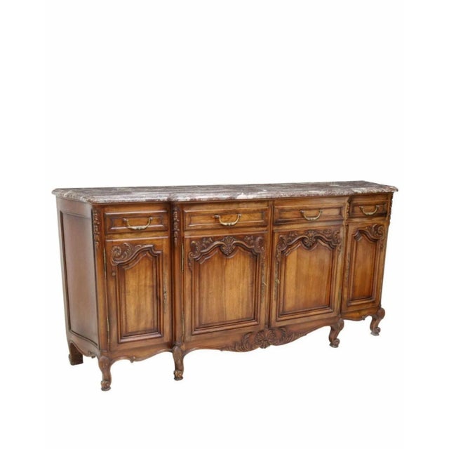 A vintage French Provincial Louis XV style carved walnut sideboard. Hand-crafted in France in the mid-20th century,...