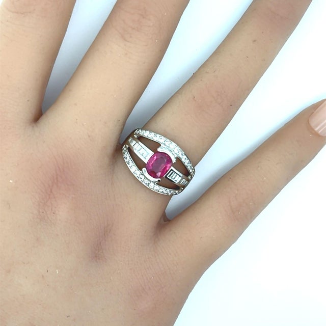 A stylish platinum band ring featuring a fine 1.46 carat ruby. The ruby has a lovely oval-shape along with a vibrant and...
