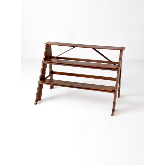 This vintage wooden plant stand features three tiers for displaying plants or decorative accents. The carved sides add...