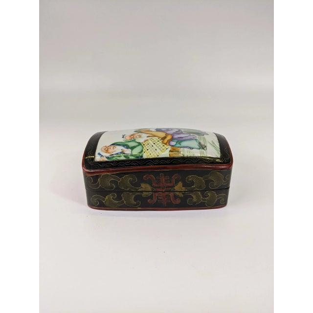 A polychrome porcelain shard lacquer box of a scene of two sages playing chess in a garden