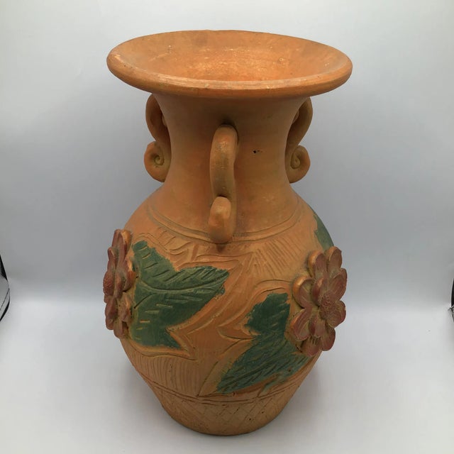 Super cool vintage Terra-cotta hand thrown vessel with three handles and raised floral design. The vessel has hand scribed...