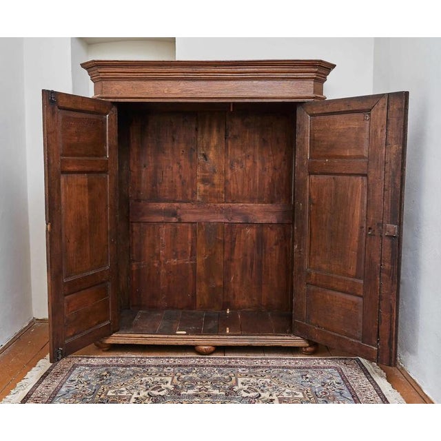 A solid oak wardrobe from the early 19th century, made using traditional craftsmanship. The front is decorated with...