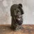 This vintage sculpture depicts the head of a Yoruba Oba, a royal figure from the Kingdom of Benin, created in the 20th...