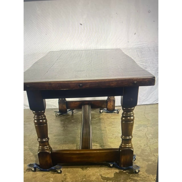 Large oak refectory table featuring turned legs, a sturdy stretcher base and bread board top. The table surface showcases...