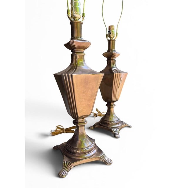 A commanding pair of heavy, solid brass vintage table lamps that beautifully bridge the gap between Neoclassical elegance...