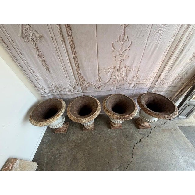 Monumental set of 4 antique French cast iron garden urns, circa 1880-1900. Each urn features a classic Neoclassical...
