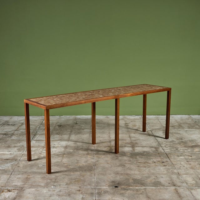 Console table by Gordon & Jane Martz. The table top is inlaid with square ceramic tiles in cream and warm brown tones. The...