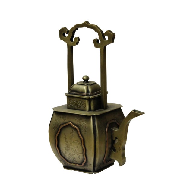A handcrafted Chinese metal bronze, square shaped teapot with a long handle, this teapot is carved with a bamboo flower on...