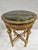 This antique round baroque side table features a gilded finish and a green marble top. The table has intricate carvings...