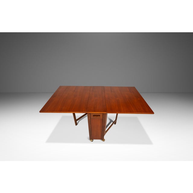 This ingenious Mid-Century Modern space-saver dropleaf table with four hidden folding chairs is a masterpiece of compact,...